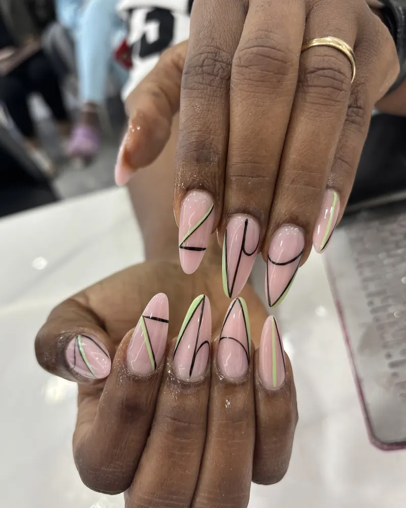 Pink stiletto nails with black and gold line art at Chillux Nails, Orpington